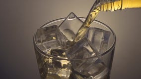 pouring-scotch-whiskey-over-ice-close-up-tracking-shot-63395649.jpg