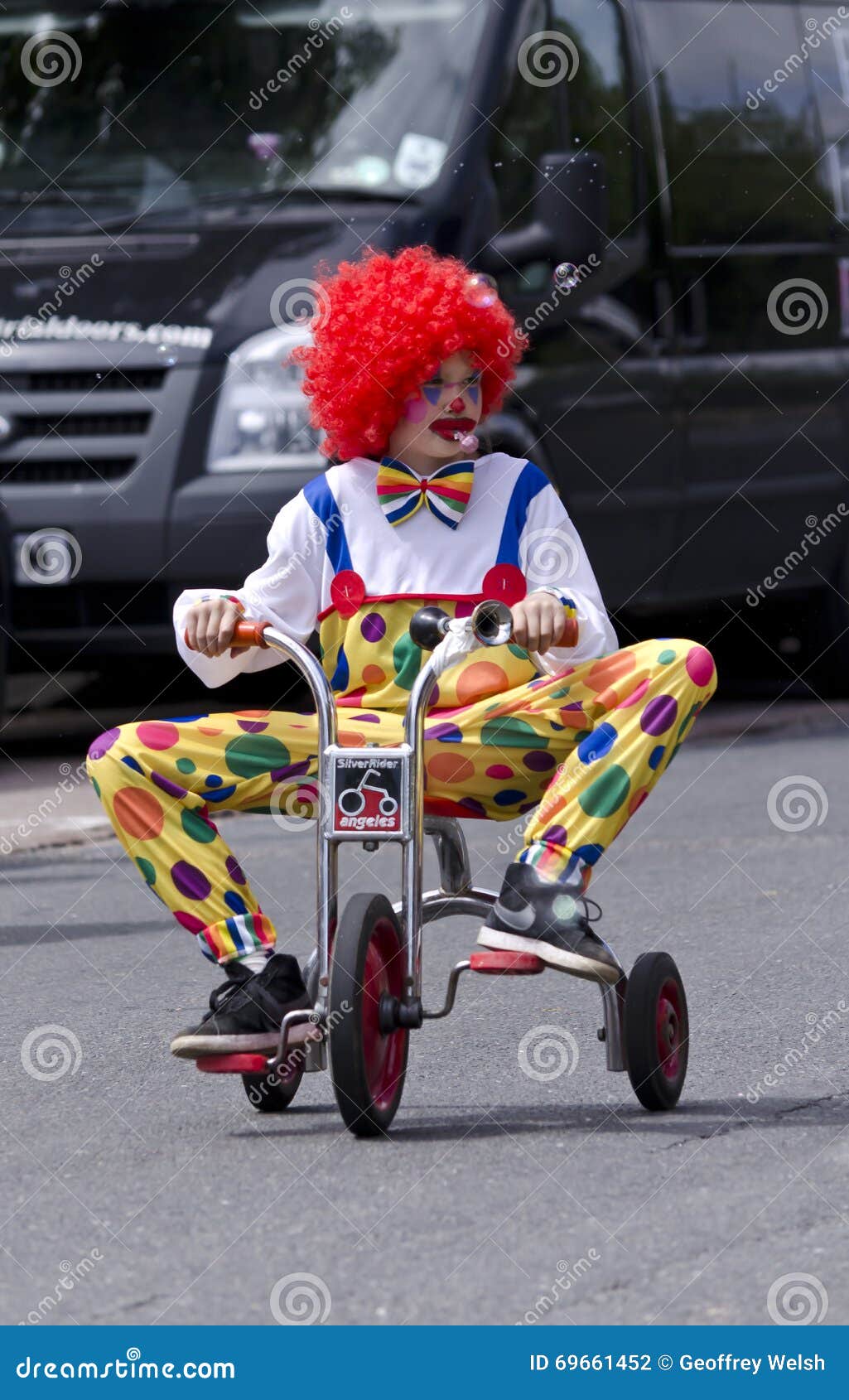 boy-dress-up-as-clown-little-clacton-essex-england-uk-june-young-ridding-small-three-wheeled-tricycle-along-road-69661452.jpg